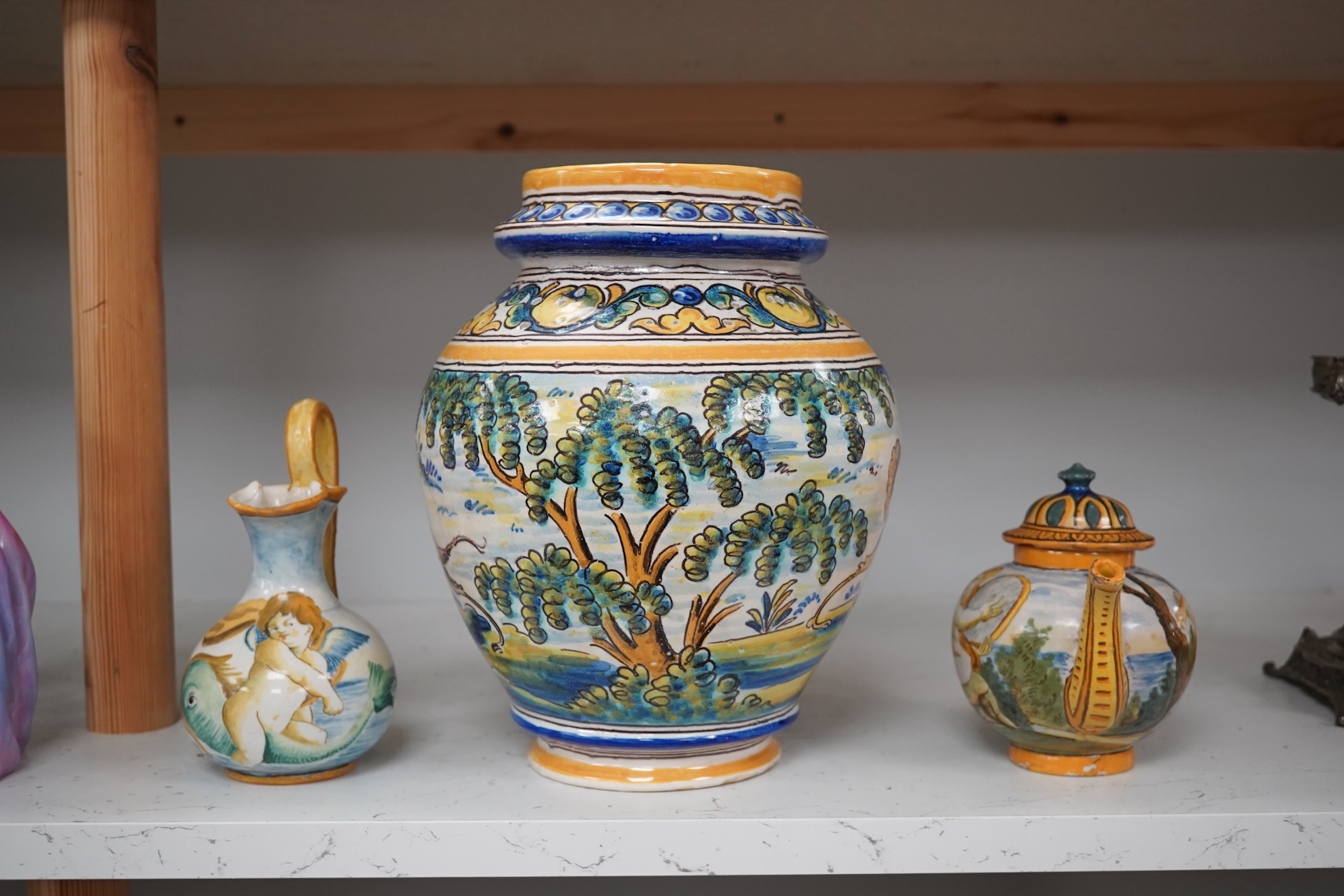 An Italian maiolica teapot and jug and a Talavera maiolica vase, 25cm high (3). Condition - jar good, teapot restored and cracked